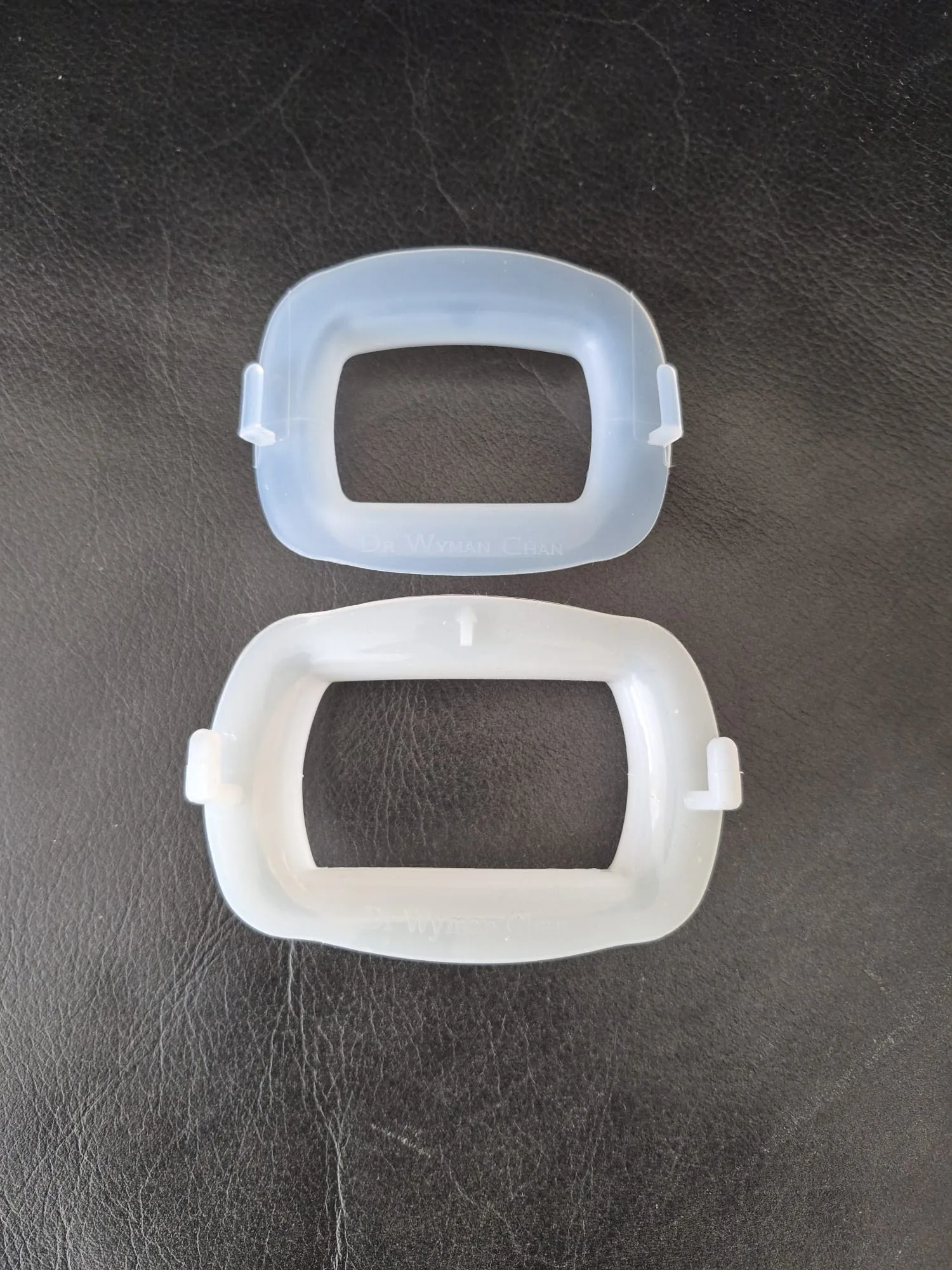 Two Wy10 O Cheek Retractors shown together: Standard and Small sizes, in translucent silicone with Dr Wyman Chan embossed detail