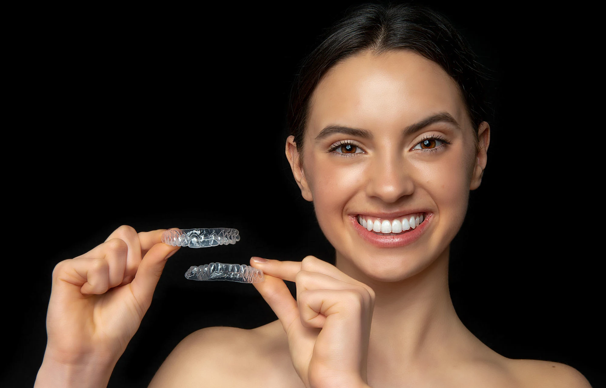 Woman holding up clear Perfect Trays bleaching trays